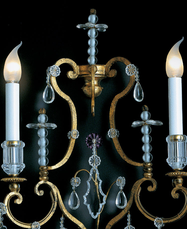 Luxury wall light in golden wrought iron and clear crystals